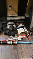 Overview of two Star Wars lightsabers, Kylo Ren costume mask with hood, and Captain Rex mask.