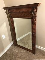 Full front view of rectangular mirror with carved frame and crown molding