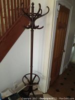 Full view of the bentwood coat rack next to staircase and wall.