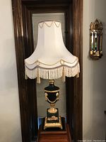 Full front view of lamp with white bell-shaped fringe shade