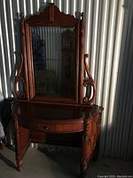 Front view of cherrywood bowfront vanity with large beveled mirror and bowed desk with drawer.