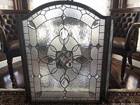 Front view of leaded glass fireplace screen showing arched central panel and bevelled glass design
