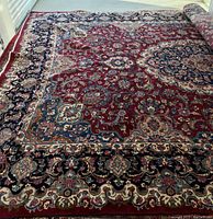 Main view of handwoven Persian Mashad rug unrolled on floor