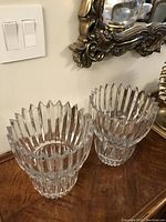 Pair of two clear glass vases shown from an angle revealing vertical ribbing and textured crown-shaped top edges.