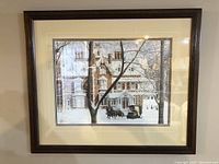 Framed winter scene print with horse-drawn carriage and house covered in snow, signed and numbered.
