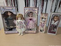 Lot of five collectible dolls, four in original boxes, one loose. Boxes show some damage. Measurement scale included in photo for size reference.