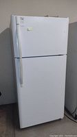 Front view of white Kenmore refrigerator with top freezer and handle on left side.