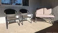 Glider and two matching chairs on patio in sunlight