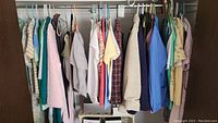 Photo showing a variety of women's clothing hanging on a rod, mainly blouses, jackets, and robes in multiple pastel and darker colors