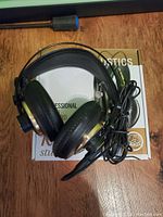 AKG K240 Studio headphones placed on original box, showing ear cushions, cable and 3.5mm plug with adapter.