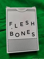 Photo of the Flesh & Bones box showing the front with black and white stylized text.