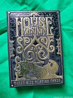 Front side of collector's card box with embossed gold lettering and lion design on black background.