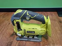 Front side of the RYOBI cordless jig saw showing brand, speed match dial, blade guard, and ergonomic handle.