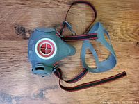 Front view of a gray rubber Scott face respirator mask with red and black adjustable straps and a 40mm thread connection valve with red and white circular detail.