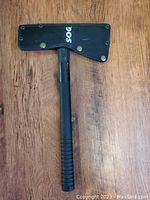SOG sport axe with protective sheath on wooden surface