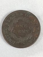 Reverse view showing denomination ONE CENT inside wreath and UNITED STATES OF AMERICA inscription.