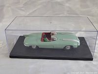 Pale green vintage Pontiac model car kit in clear display case, showing side and top view details.