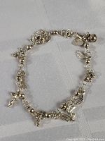 Top view of sterling silver charm bracelet with multiple detailed western-themed charms and beaded chain links