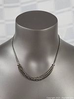 Front view of sterling silver multi-strand necklace displayed on a mannequin bust, showing chain design and patina.