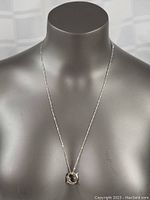 Full view of the sterling silver necklace displayed on a mannequin, showing the length and pendant placement.
