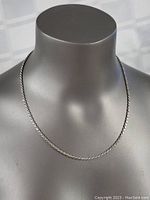 Necklace displayed on mannequin showing full length and braid link pattern.
