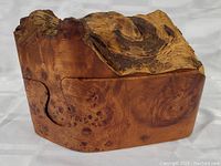 Front angle of the burl wood puzzle sculpture showing natural wood grain, knots, and smooth finish.