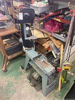 Wide-angle view of band saw on bench stand in workshop