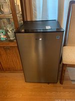 Front view of Danby bar fridge showing stainless steel door and black top.