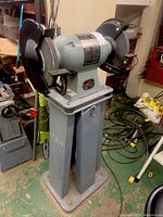 Front view of entire bench grinder mounted on pedestal stand
