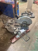 Front side view of the Concept MS100 sliding compound mitre saw showing blade, sliding arm, and base clamp