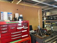 Wide view of cabinet tops showing drill bit holders, spade bits, case and scale