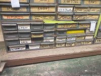 Close-up of lower drawers labeled for assorted nails, hooks, and fasteners