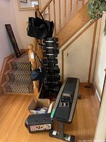 Full lot against staircase showing rack, bench, adjustable set, gloves box, and bats