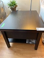 Side view of the dark wood side table showing the rectangular top, legs, and lower shelf.