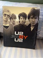 Front cover of 'U2 By U2' book showing the band members Bono, The Edge, Adam Clayton, and Larry Mullen Jr.