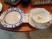 Top view of the three items showing Dedham Pottery plate, Christmas bowl, and floral platter on a wooden table.