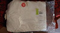 Full view of vintage cotton lace bed cover in original packaging with price discount sticker.