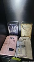 Photo showing four men's dress shirts including two Christian Dior shirts in packaging and a pack of boxer shorts.