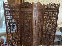 Front view of four-panel carved teak wood folding screen with floral and geometric carved panels