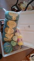 Overall view of the white storage bin filled with assorted wool and yarn skeins and balls, including multiple Marble Chunky brand skeins