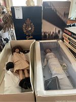 Four Barbie dolls in original or partially opened packaging with Ralph Lauren, Donna Karan, and Jackie Onassis themes.