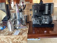Coffee maker and drinkmaster with accessories displayed on table.