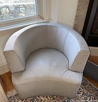 Full front view of light gray swivel chair showing curved back and seat.