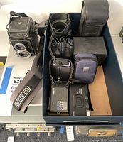 Overview of Rolleicord TLR, Zeiss lenses pouches, digital cameras, cases and strap in box