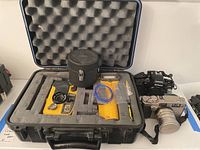 Black hard transport case open showing Sea & Sea underwater camera set, Sekonic light meter, Contax G2 and Nikon N8008S