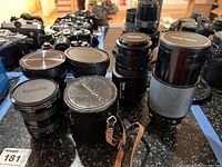 Photo of multiple vintage lenses including Vivitar 75-200mm, Samyang, and Soviet lenses with carrying cases.
