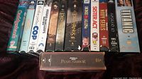 Photo of miscellaneous movie videos VHS tapes including Gods and Monsters, The Lord of the Rings, Home Alone, Sister Act, Navy SEALs, Apollo 13, Titanic, and Pearl Harbor
