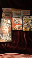 Photo showing 11 assorted never opened DVD movies with various titles such as Chuck Norris Collection, Sentinel, Faster, The Little Drummer Boy, Godfellas, Face Off, and others.