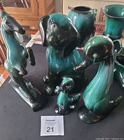 Four Blue Mountain Pottery animal figurines displayed on black surface showing horse, dog, large duck, and smaller duckling with distinct glazing.