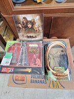 Photo showing the 3D puzzle box, Saruman figure packaging, and Lord of the Rings poster in background